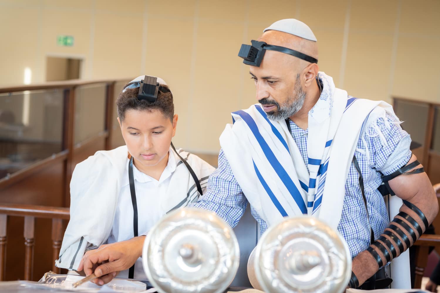 Barmitzva-boy-with-dad-reading-torah Bar mitzva photograph of a boy with his father helping him read the torah in synagogue